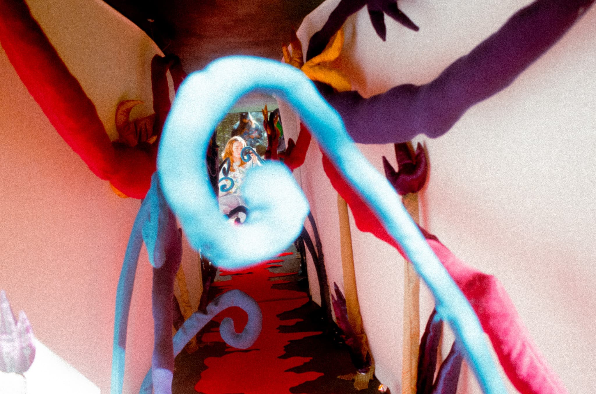 A tentacled fabric tunnel installation in red, blue, and purple