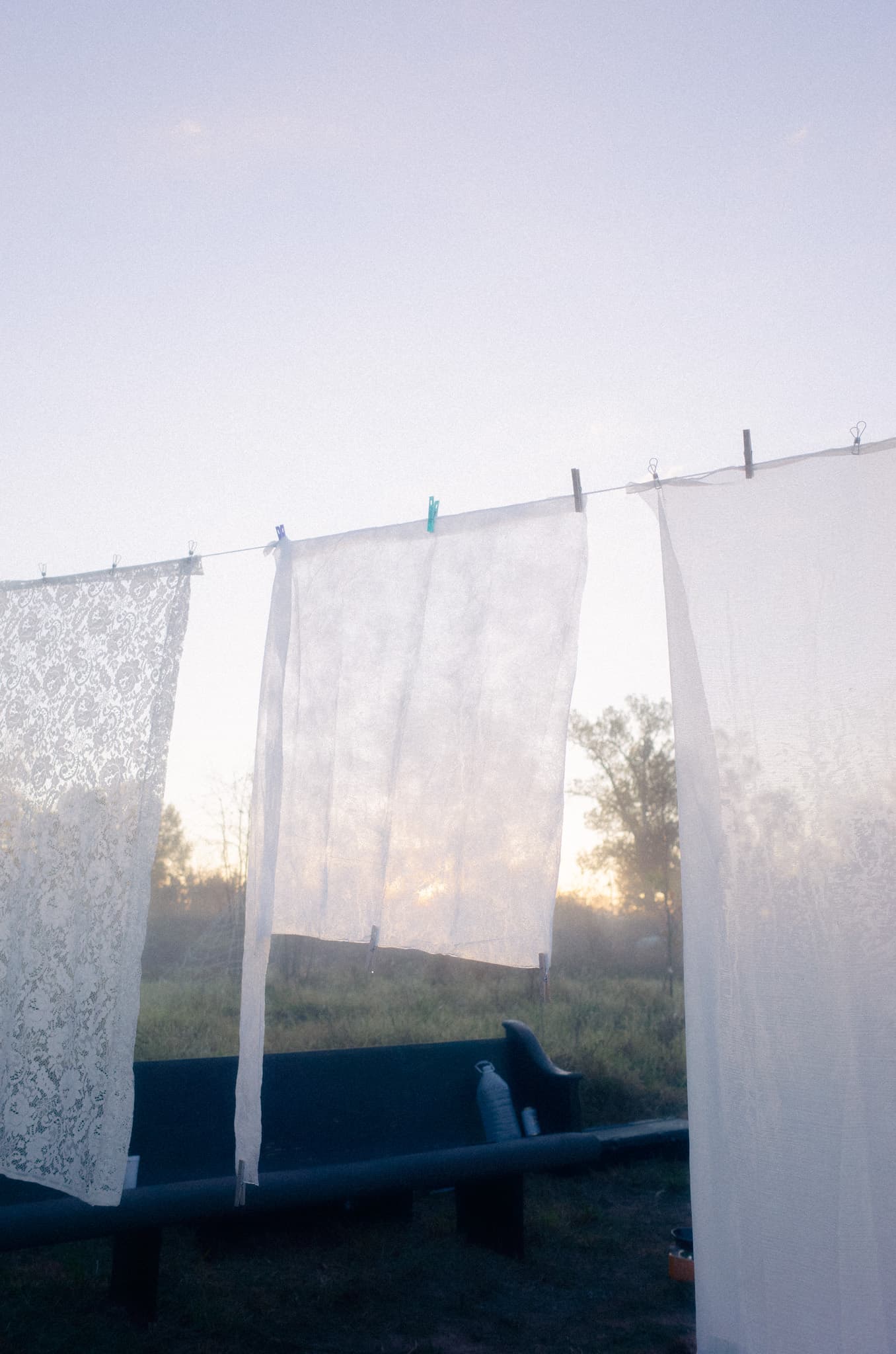 Lace and linen sheets drying on a line at dawn